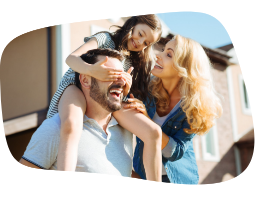 Casal com uma filha, que está sentada nos ombros do pai tapando seus olhos