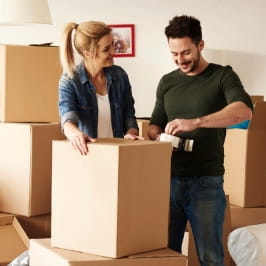 Homem e mulher embalando caixas de mudança.
